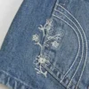 Ultra Low-Rise Medium Wash Floral Embroidered Denim Mini Shorts Ultra Low-Rise Medium Wash Floral Embroidered Denim Mini Shorts